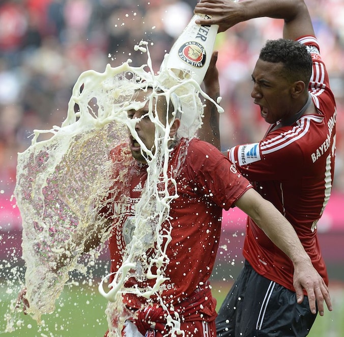 Verdediger Jerome Boateng (r) giet een grote pint bier uit over het hoofd van Franck Ribéry (l).