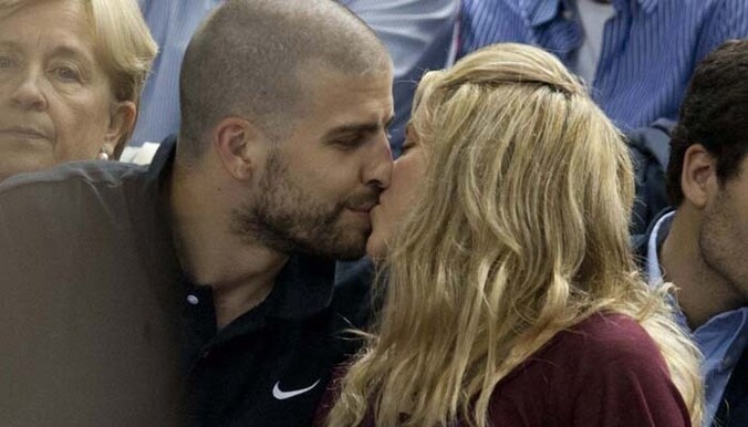 Gerard en Shakira zoenend bij een basketbalwedstrijd.