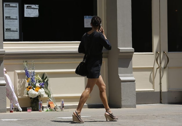 Een vrouw passeert bloemen die ter nagedachtenis zijn neergelegd bij het appartement van James Gandolfini in New York.