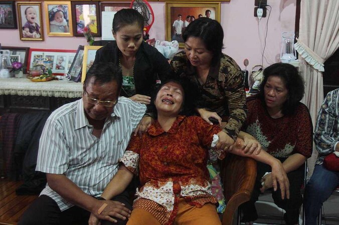 De ouders van de omgekomen Firman Chandra Siregar met op de achtergrond drie familieleden.