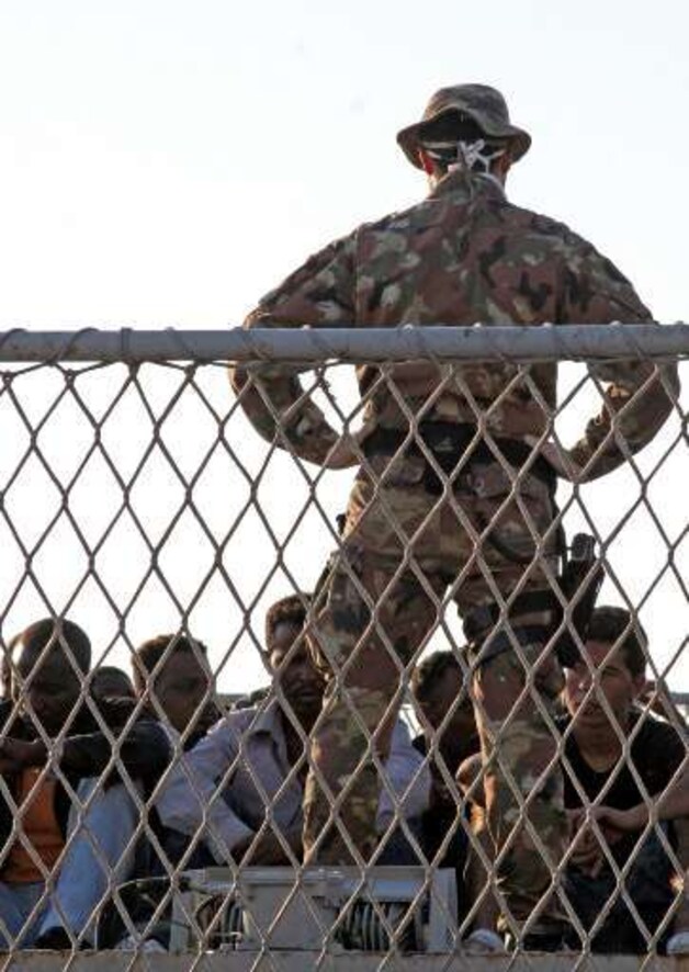 Een Italiaans soldaat bewaakt een opvangcentrum voor illegalen in Lampedusa.