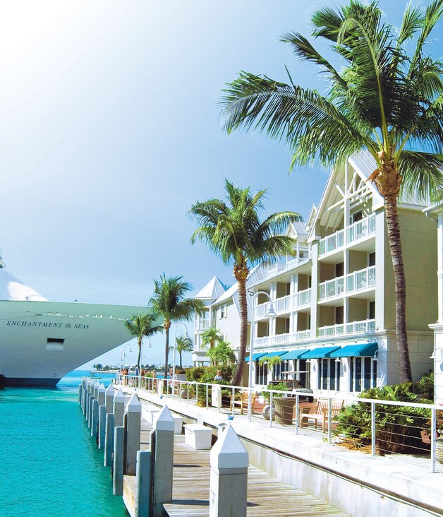 Een cruiseschip ligt op Key West aangemeerd aan de kade die afgeboord wordt door huizen in koloniale stijl.