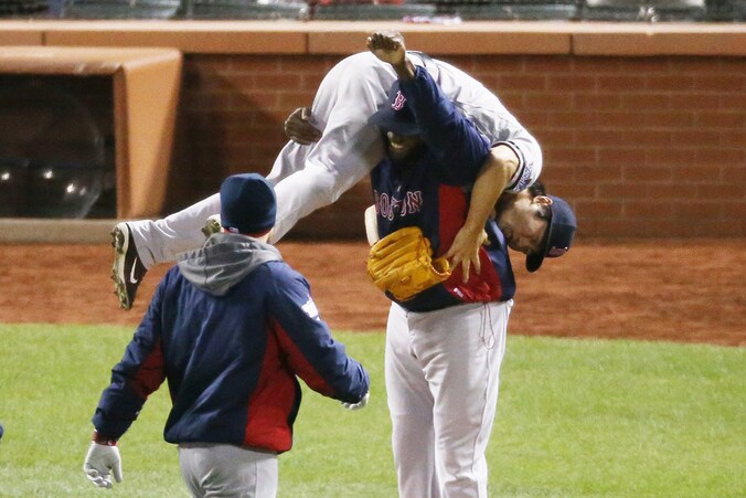 Red Sox-werper Koji Uehara gaat op de schouders bij ploeggenoot David Ortiz nadat hij Cardinals-speler Kolten Wong heeft uitgegooid.