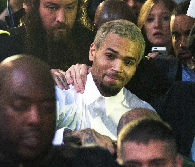 Chris Brown wordt omstuwd door omstanders nadat de rechter hem maandag op vrije voeten heeft gesteld.