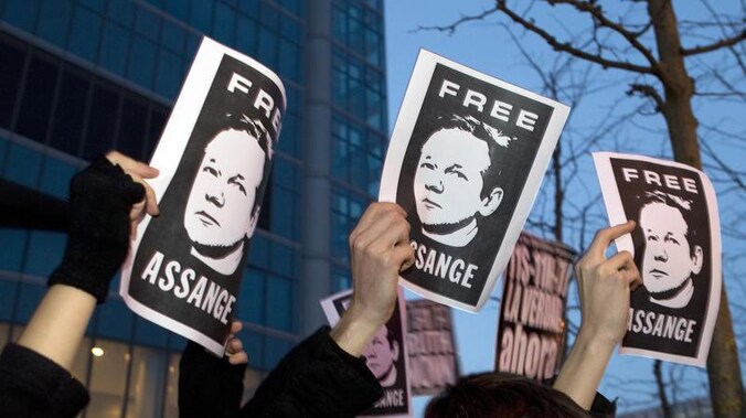 Betogers voor de Britse ambassade in Madrid eisen de vrijlating van Julian Assange.
