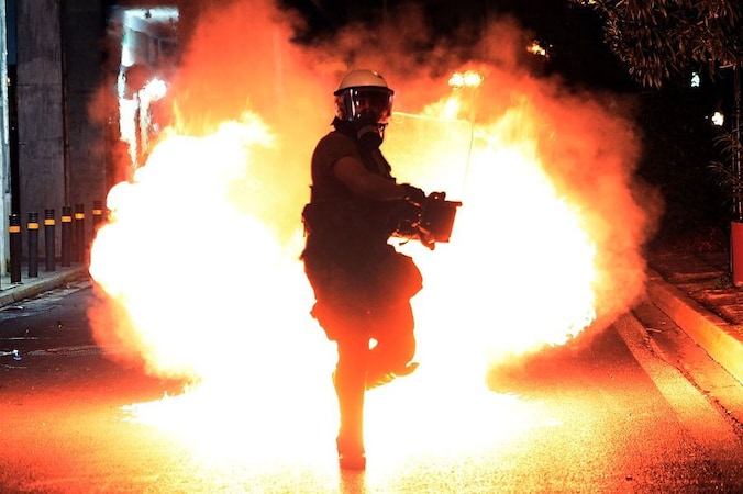 Een molotovcocktail ontploft vlak bij een lid van de oproerpolitie, gisteren tijdens een protestmars in Athene naar aanleiding van de moord op de linkse rapper Pavlos Fyssas.