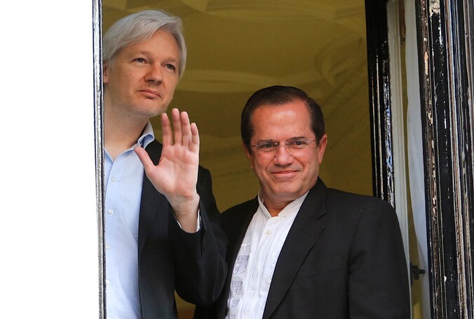 Assange met minister Patino, vanuit het raam van de ambassade Ecuador