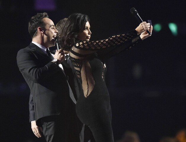 Kim Kardashian poseert voor een selfie op het podium. Ze kondigde er haar echtgenoot Kanye West aan.