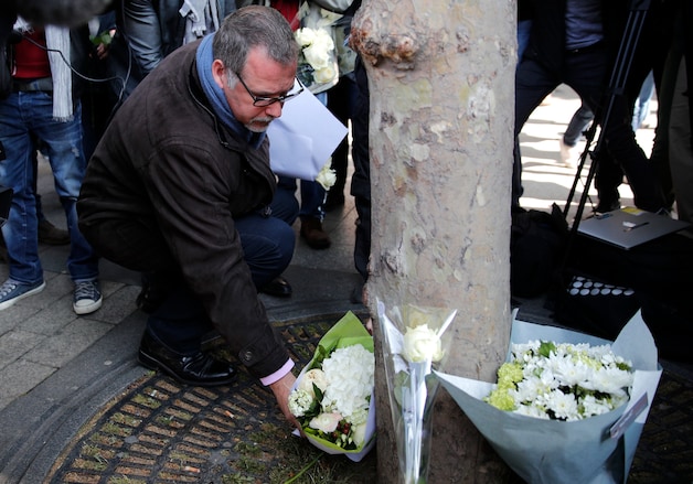 Vertegenwoordiger van de politievakbond Denis Jacob legt bloemen op de plek waar de agent vermoord werd.
