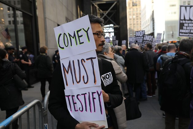 Een actievoerder voor de Trump Tower in New York eist dat Comey komt getuigen voor de senaatscommissie.