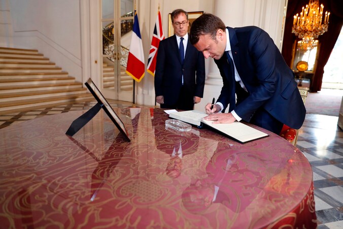 De Franse president Emmanuel Macron tekent in de Britse ambassade in Parijs het rouwregister voor de slachtoffers van de aanslag in Manchester.