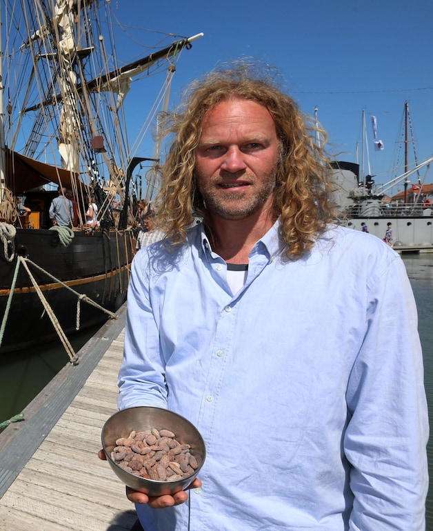 Kapitein Arjen Van der Veen met een kommetje cacaobonen.