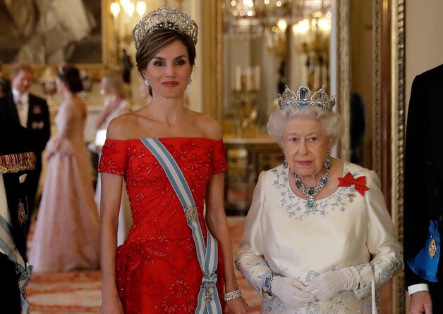 De Spaanse koningin Letizia met de Britse Queen, prinses Kate in de achtergrond in gesprek met prins Harry.