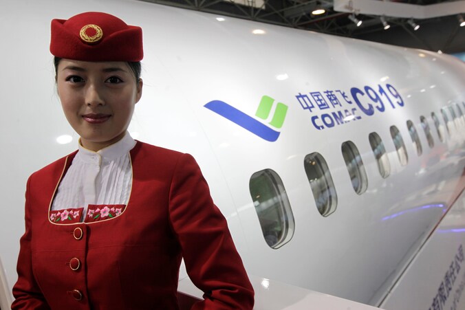 Een personeelslid van de Chinese luchtvaartmaatschappij Commercial Aircraft Corporation of China (Comac) poseert bij een voorbeeldmodel van een C919.