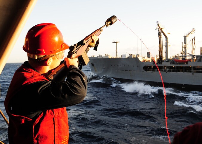 Een opvarende van het Amerikaanse marineschip USS George Washington schiet een lijn naar het oliebevoorradingsschip USNS Tippecanoe bij een eerdere gemeenschappelijke oefening van de Verenigde Staten en Zuid-Korea.