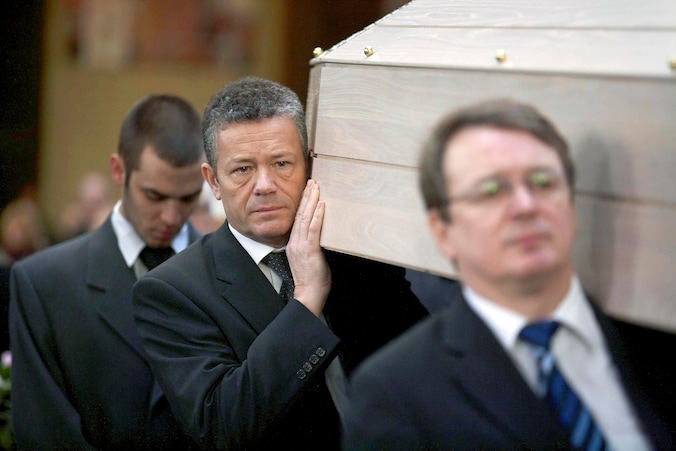Echtgenoot Frank Vanhecke en VB-senator Jürgen Ceder dragen mee de kist de kathedraal binnen.