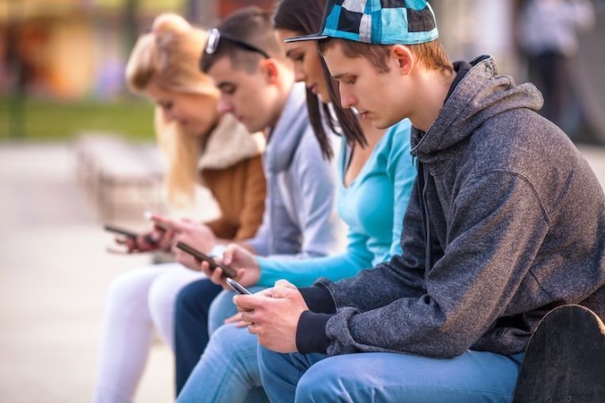 Jongeren zijn bezig met hun smartphone.