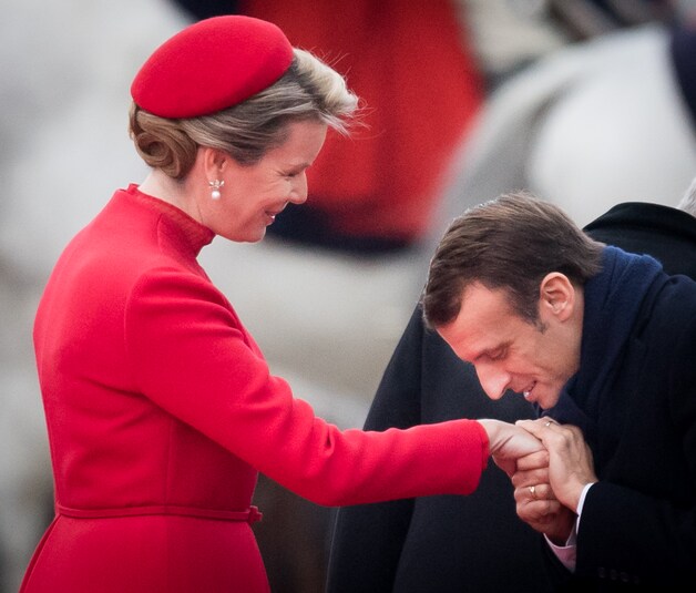 Met alle egards: het respect van andere staats- hoofden voor onze immer stijlvolle koningin is groot. Mathilde beantwoordt de handkus van (naamgenoot van haar jongste zoon) Macron, vorig jaar op bezoek in Brussel, met een hoofdknikje.