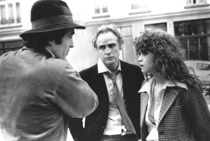 Bernardo Bertolucci, links, hoofdrolspeler Marlon Brando, in het midden en actrice Maria Schneider 