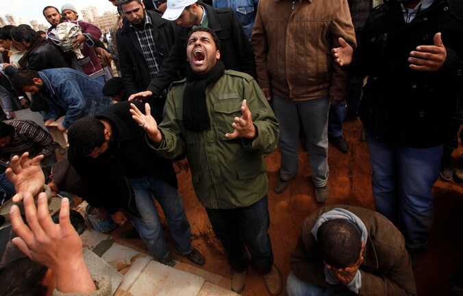 Rouwende rebellen in Ajdabiyah, Libië. Eén van hun strijdmakkers kwam er om het leven.