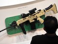 Een bezoeker van een beurs bekijkt een Ultimax 100 MK8, een wapen van Singaporese makelij.