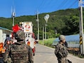 Zuid-Koreaanse militairen op wacht in Muju (Zuid-Korea), terwijl in de elektriciteitsdraden ballonnen met afval en uitwerpselen hangen, vermoedelijk afkomstig uit Noord-Korea.