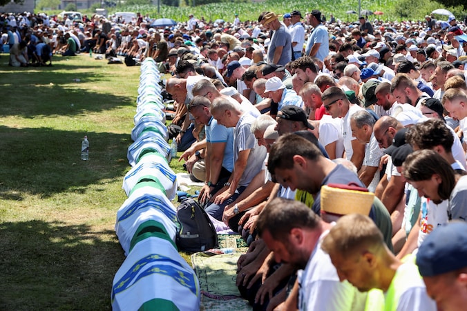 Bosnische moslimmannen bidden tijdens een massabegrafenis bij het Srebrenica Genocide Monument in Potocari, Bosnië en Herzegovina.
