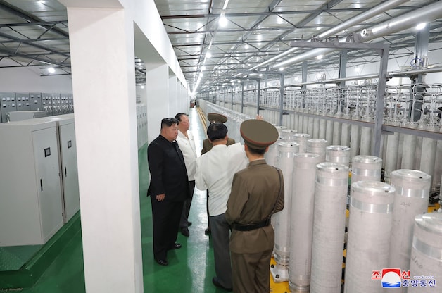 Leider Kim Jong-un (in het zwart) inspecteert de productiebasis van kernwapenmateriaal op een onbekende locatie in Noord-Korea