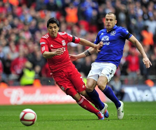 John Heitinga (r) namens Everton in duel met Luis Suárez.