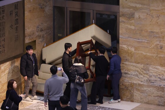 Personeel van de oppositie barricadeert een deur in het Zuid-Koreaanse parlement.