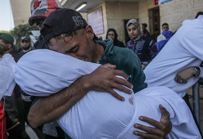 Mohammed Abu Saied treurt terwijl hij het lichaam van zijn vierjarige dochter Sila draagt, in Deir Al Balah, centraal in de Gazastrook, op 9 december 2024.
