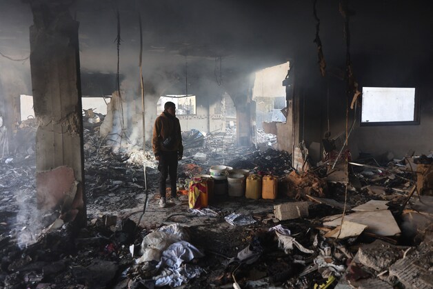 Een Palestijnse man inspecteert de schade na een Israëlische luchtaanval op een gebouw in de Daraj-wijk van Gaza-stad op 17 december 2024