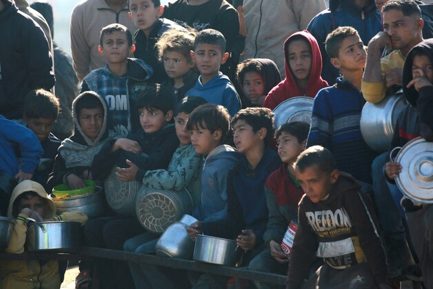Palestijnse kinderen staan te wachten op een portie eten in een distributiecentrum ten zuiden van Khan Yunis in de zuidelijke Gazastrook op 17 december 2024
