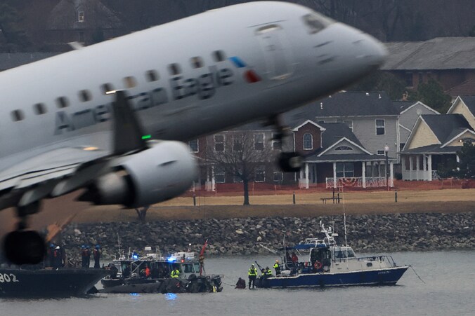 Een vliegtuig stijgt op terwijl bergingsploegen werken bij het wrak van de neergestorte helikopter in de Potomac-rivier bij Washington. (31/01/25)