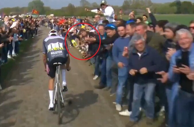 Een toeschouwer gooit een bidon in het gezicht van Mathieu van der Poel.