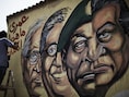 Een graffitikunstenaar schrijft in het Arabisch "Ik zal je nooit vrede wensen" naast de afbeeldingen van oud-president Moebarak (R), legerleider Hussein Tantawi en de presidentskandidaten Amr Mussa (midden) en Ahmed Shafiq (L).