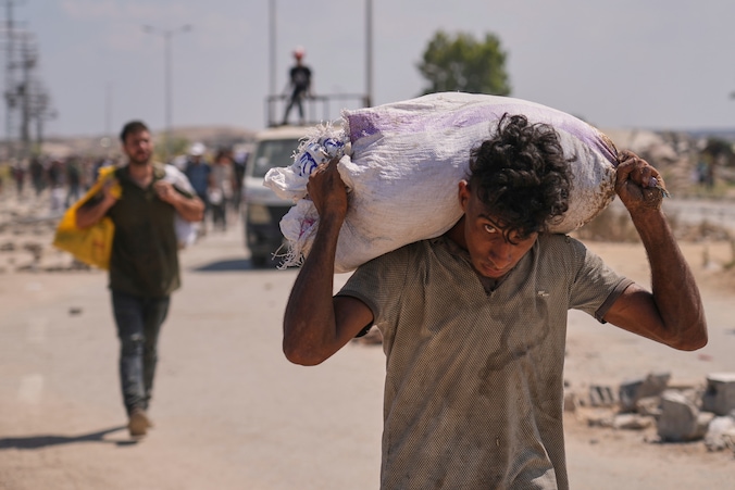 Burgers komen met gevaar voor hun leven hulppakketten halen bij een distributiepunt van Gaza Humanitarian Foundation.