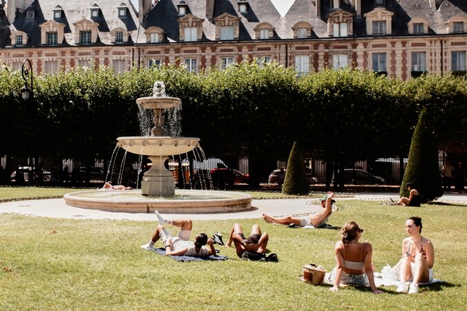 Zonnekloppers op de Place des Vosges in Parijs tijdens een hittegolf. 