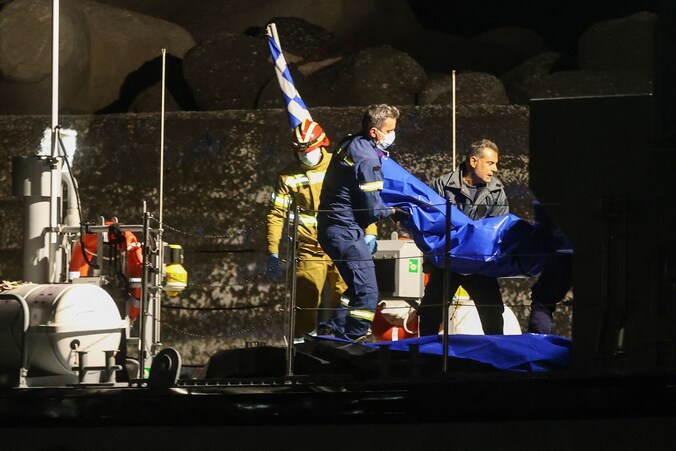 Lichamen van op de migrantenboot omgekomen slachtoffers worden aan land gebracht door de Griekse brandweer en kustwacht.