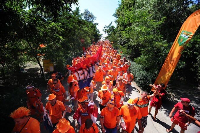 Oranjesupporters van het Nederlands elftal vertrekken vanaf de Oranjecamping in een optocht naar een wedstrijd op het EK 2012