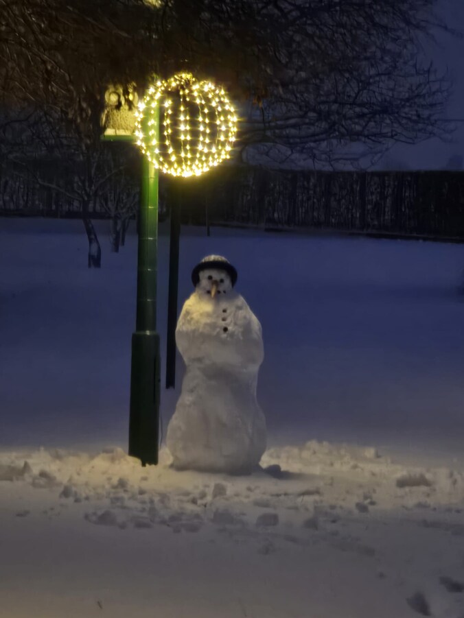 Lola (7) bouwde samen met haar grootvader een sneeuwpop.