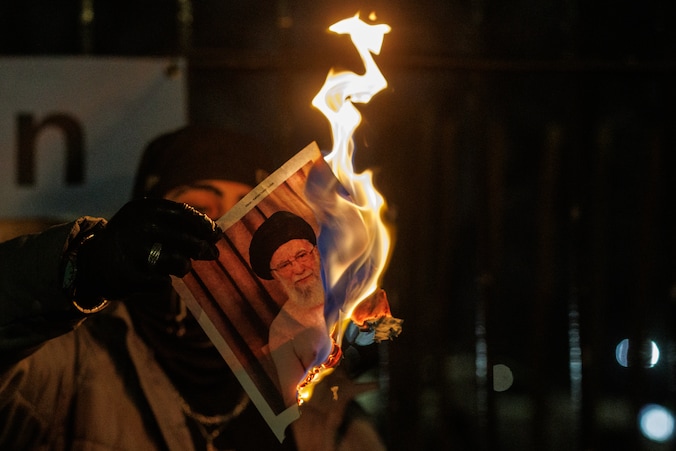 In Londen verbrandt een demonstrant een foto van Ali Khamenei, de hoogste leider van Iran, uit solidariteit met de Iraanse bevolking, die protesteert tegen het regime.  