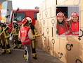 Amelie en Mila (9, inzet) uit basisschool Spoor 17 slopen samen met brandweervrouwen de symbolische ‘gendermuur’ in Tessenderlo.