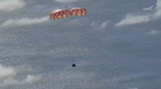 Beeld van de Orion-capsule met succesvol uitgeklapte parachutes.