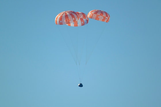 Het moment waarop het Orion-ruimtevaartuig met de bemanningsleden van Artemis II aan boord het oppervlak van de Stille Oceaan nadert.