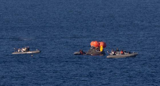 Recoveryteams snellen ter plaatse om de crew uit de capsule te halen.