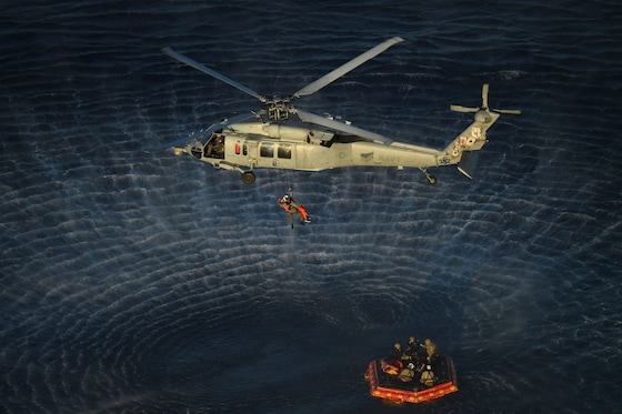 Het moment waarop de astronauten één voor één uit een reddingsbootje wordt gehesen.