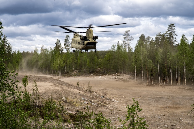 An American Chinook helicopter with NAVO troops in Tijdens and training in an open area.