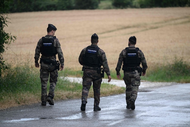 Gendarmes walk on a road in Puycasquier, close to the site where a body was found. (04/06/26)
