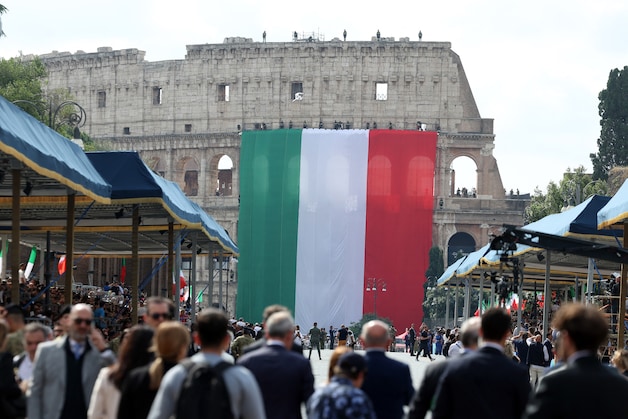 An Italian flag is lowered over the Colosseum as heads of state and government guests attend the traditional military parade.